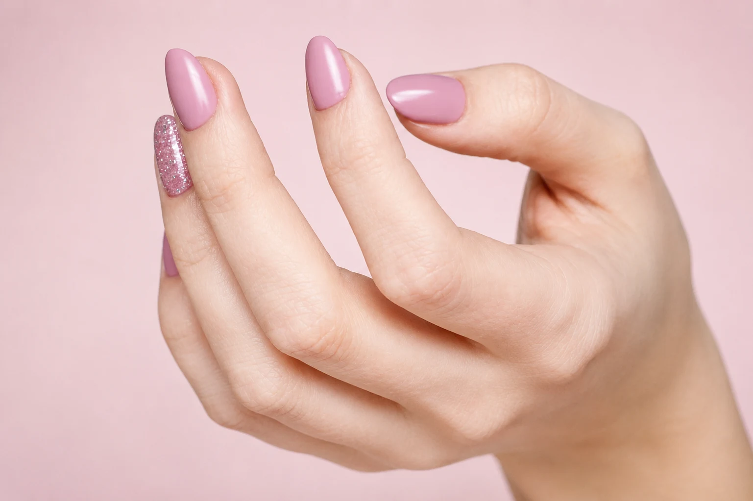 Vibrant pink press-on nails scattered under blue light